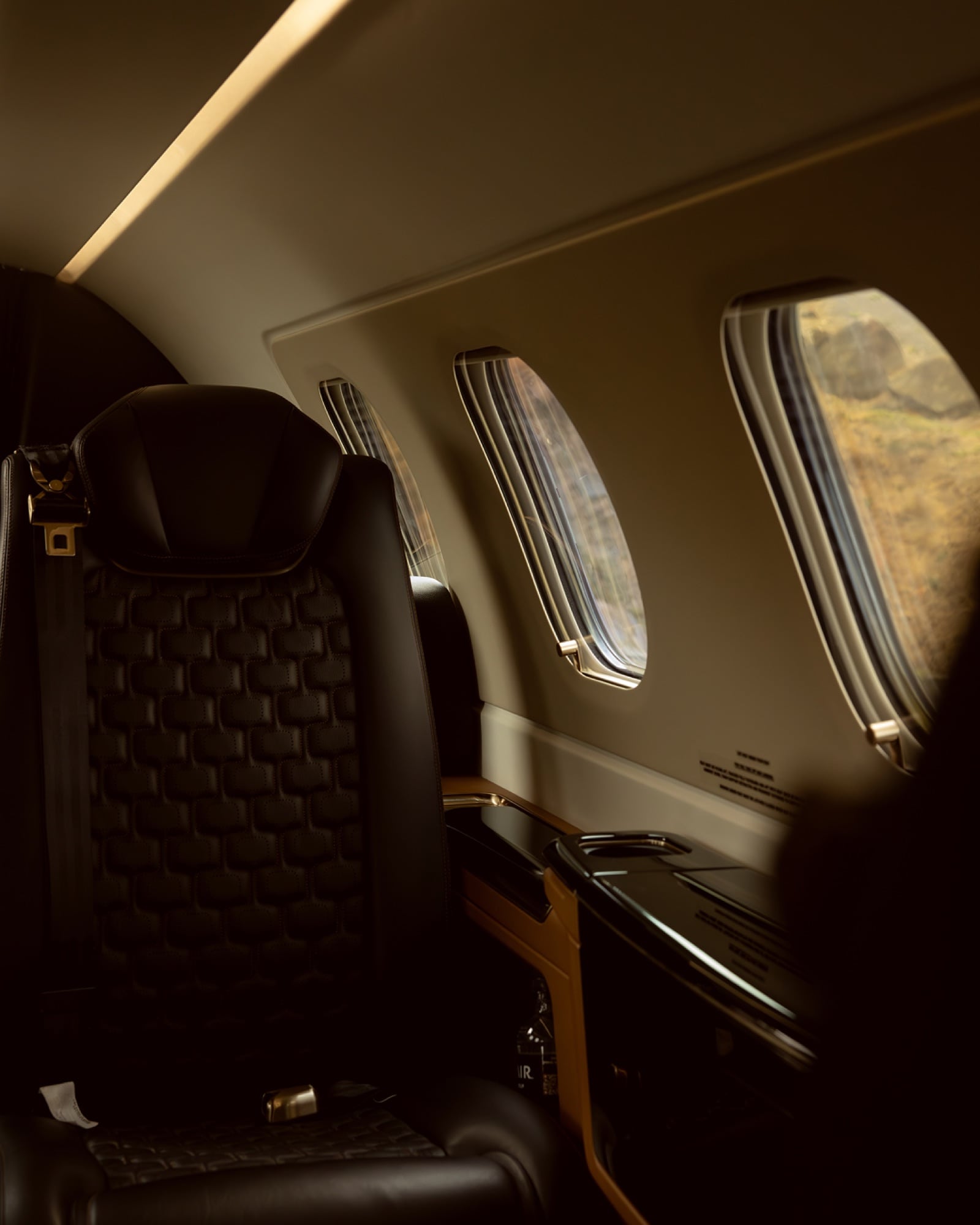 Inside the Phenom 300E — quilted leather and oversized windows in the class's tallest cabin
