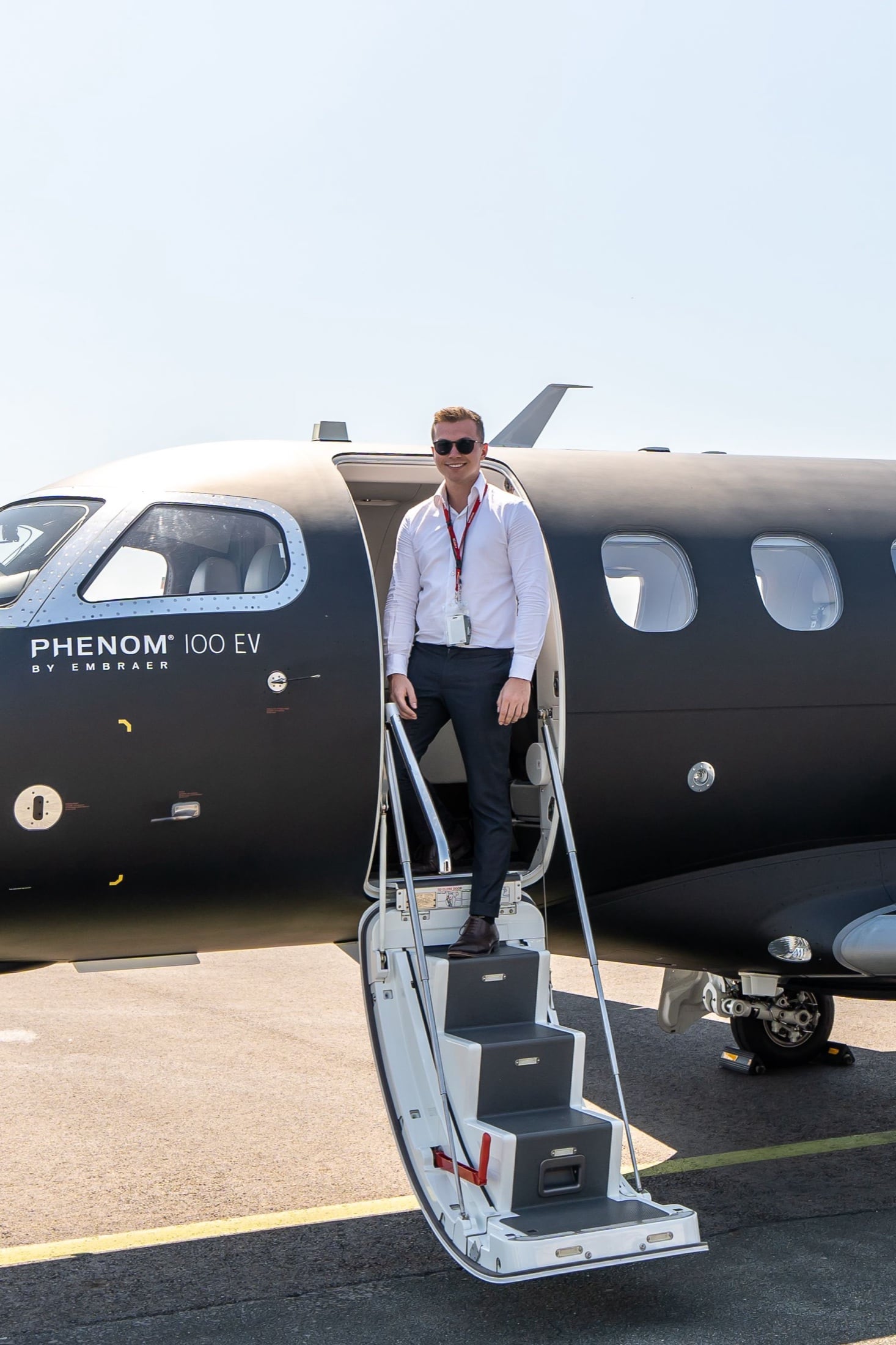 Founder Zac George standing at the door of a black Phenom 100EV