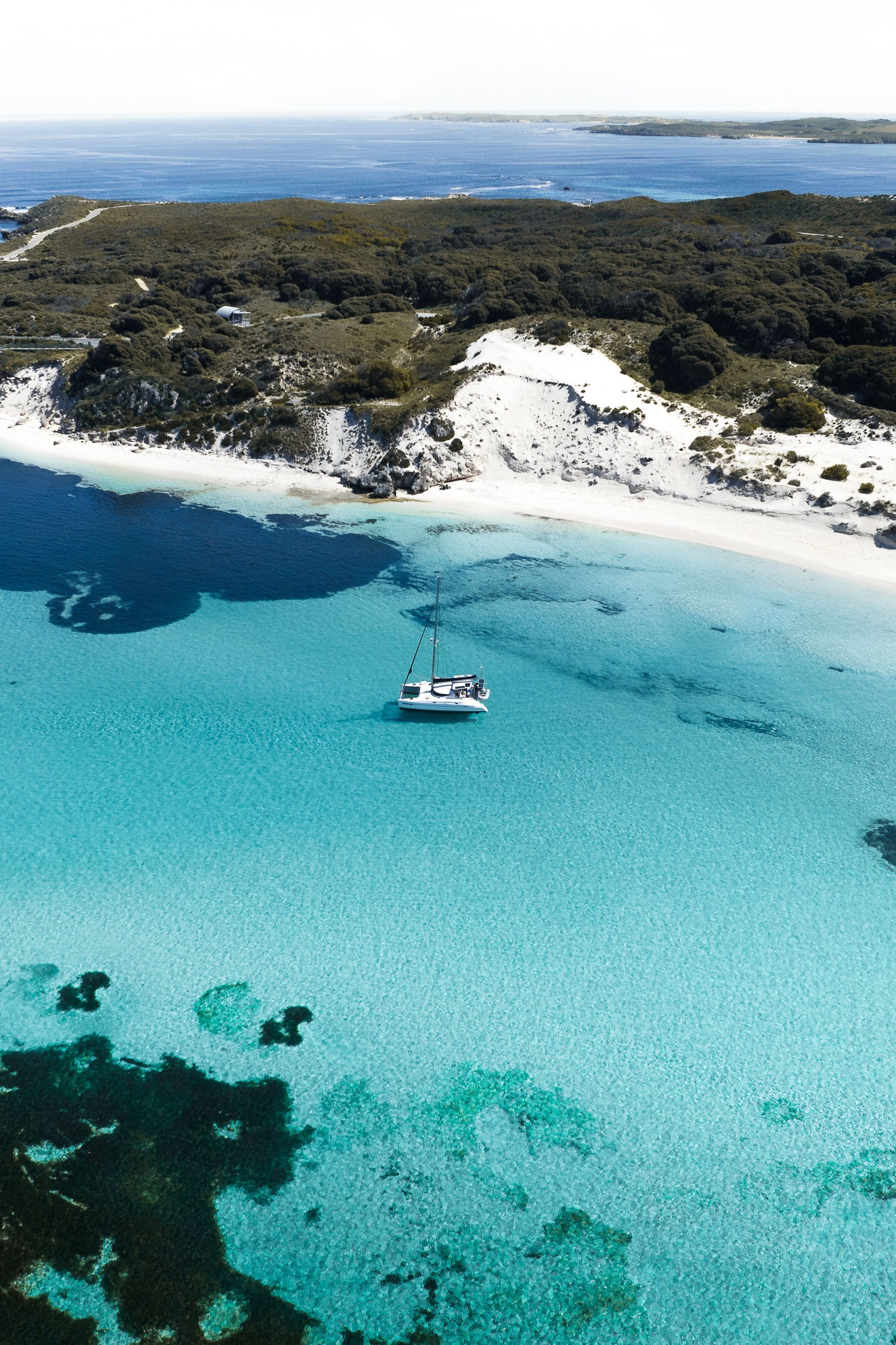 Catamaran anchored in a clear turquoise bay off Rottnest Island near Perth