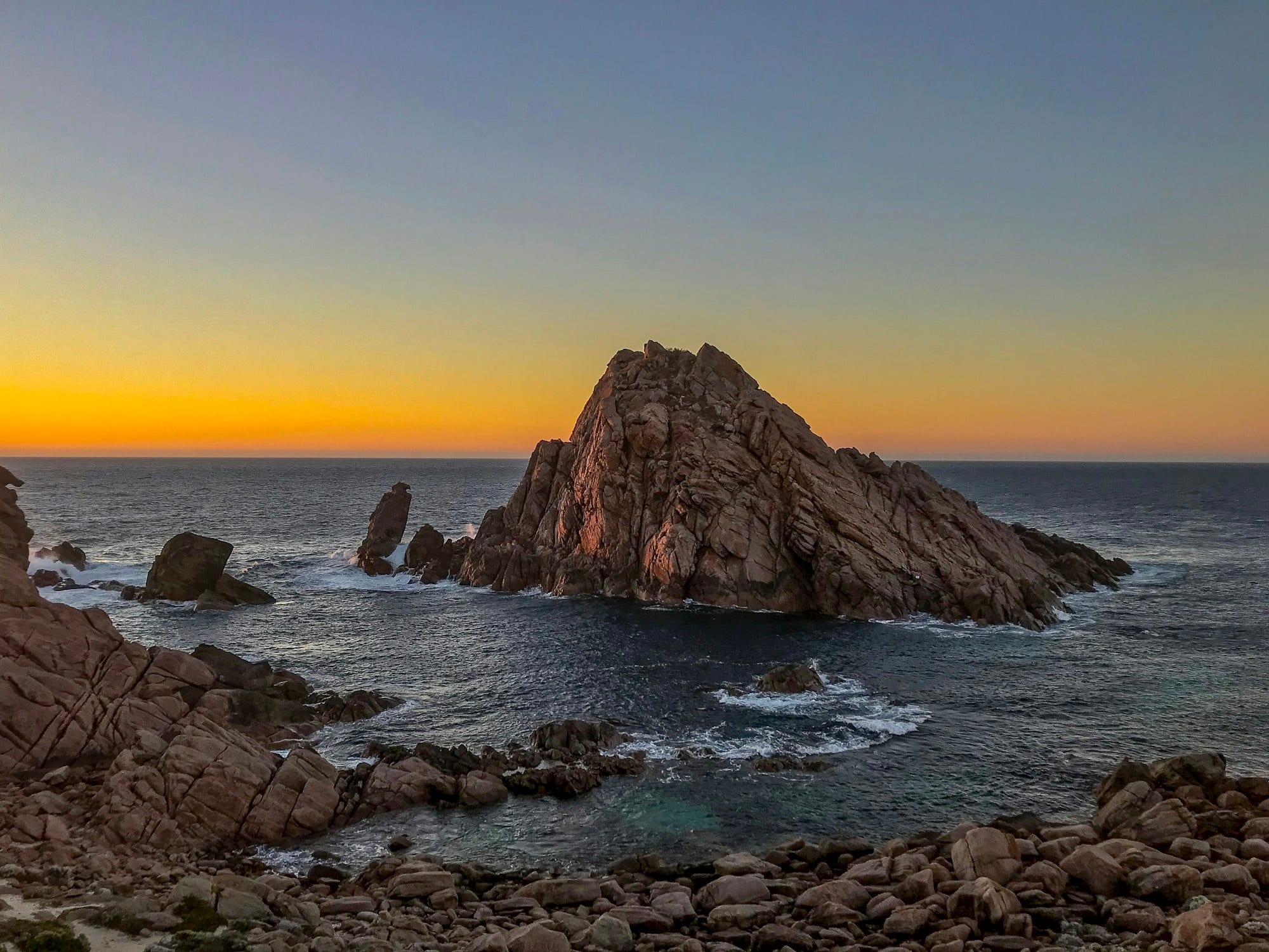 Sugarloaf Rock rising from the Indian Ocean at dusk near the Margaret River region