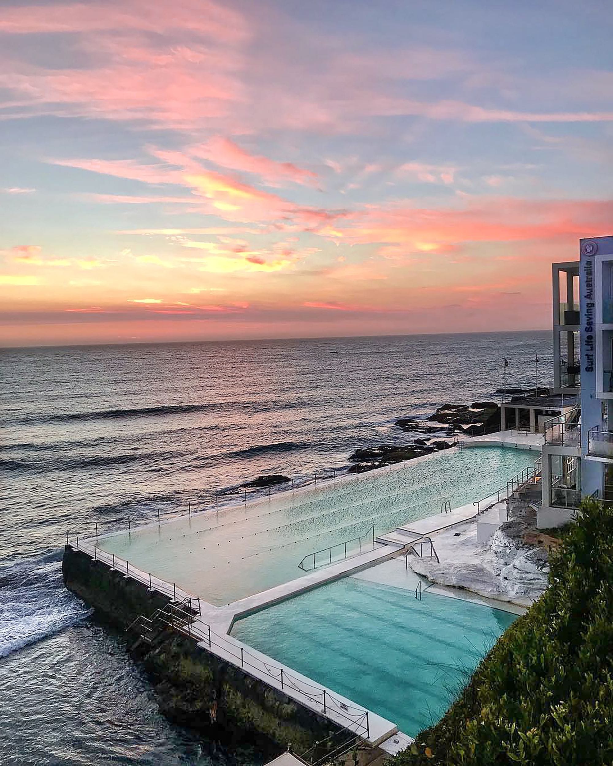 Bondi Icebergs ocean pool at sunrise beneath pink and gold skies, Sydney