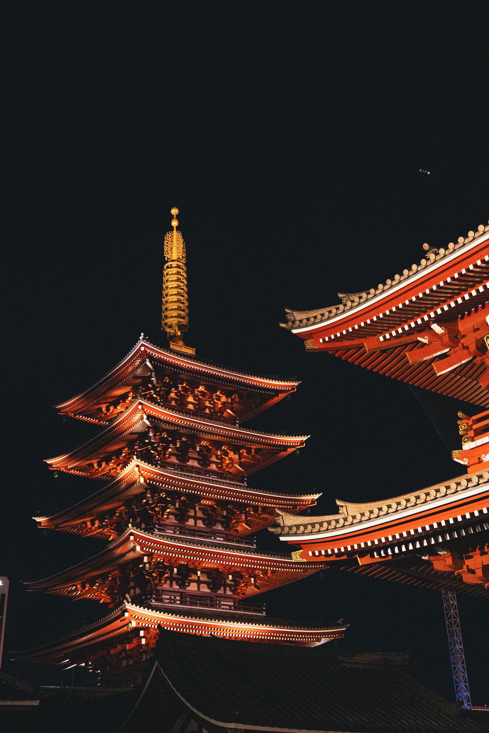 Senso-ji's five-storey pagoda and temple eaves glowing against the night sky in Asakusa