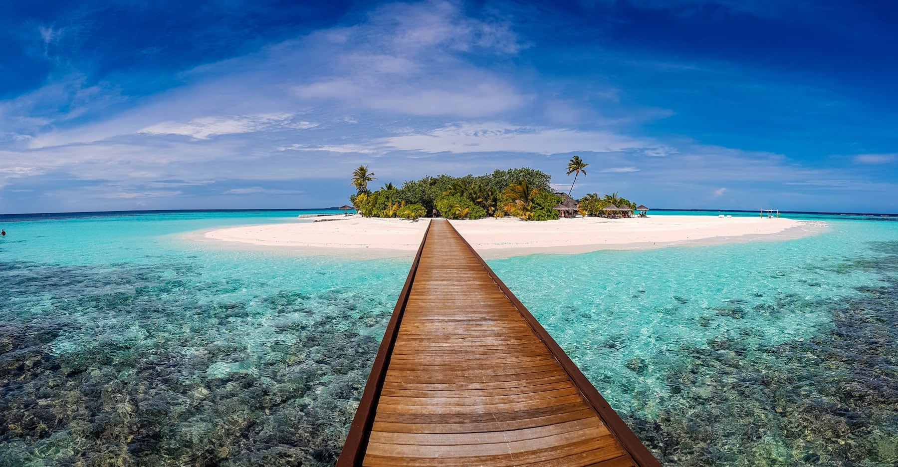 A timber jetty leading to a private island over turquoise water