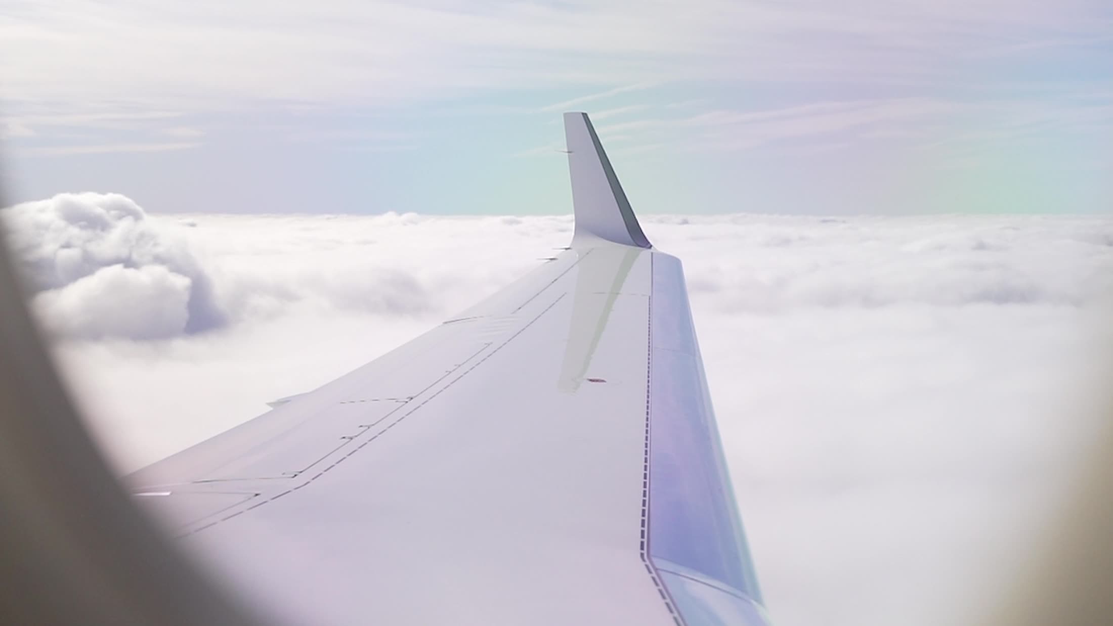 A jet wing over an unbroken cloudscape at cruise