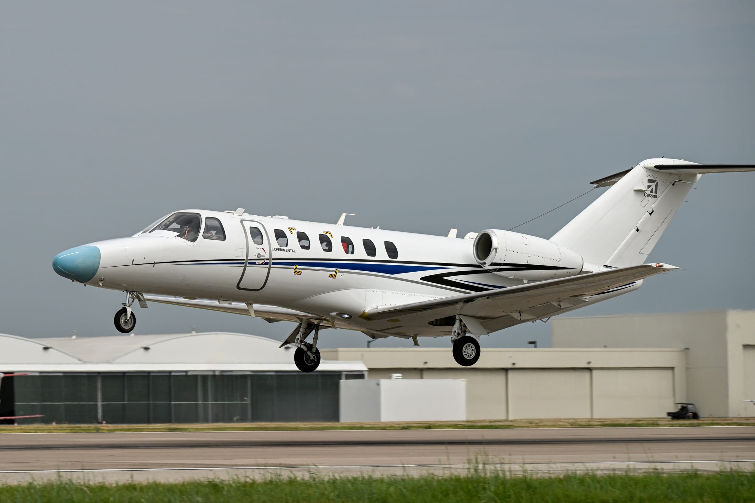 The Citation CJ3 Gen3 prototype lifting off the Wichita runway on its first flight, test boom on the nose and Experimental titles by the door