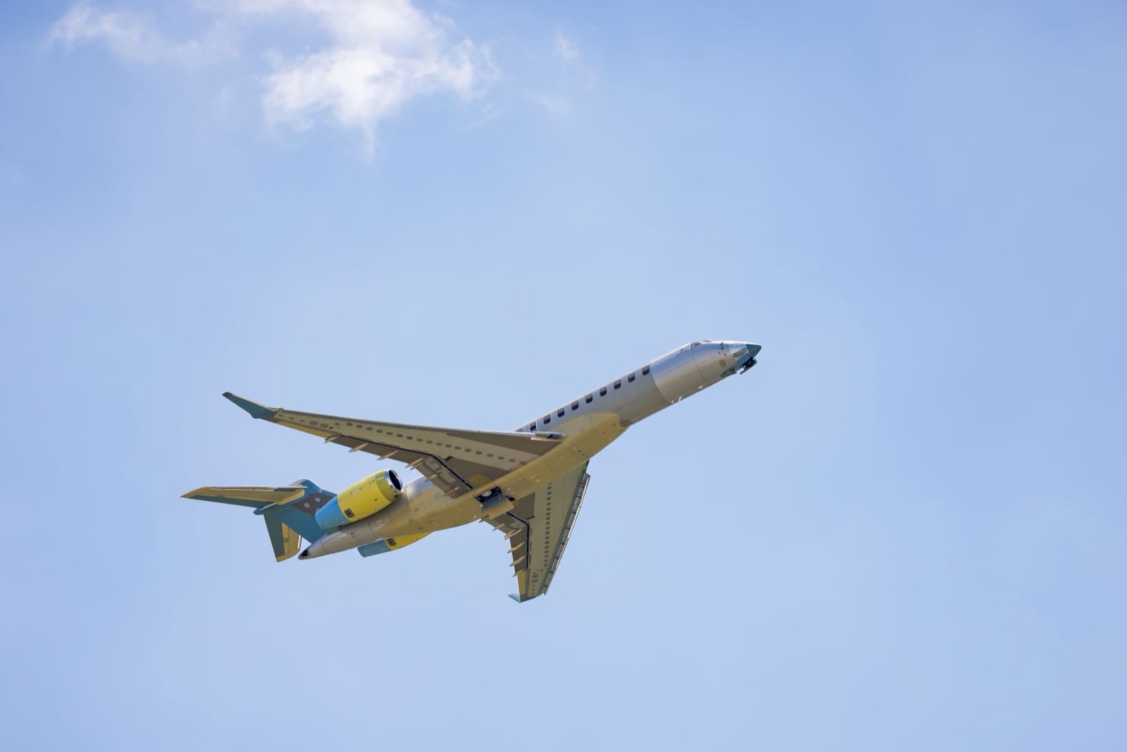 The first production Global 8000 climbing in green-and-yellow primer, unpainted before delivery