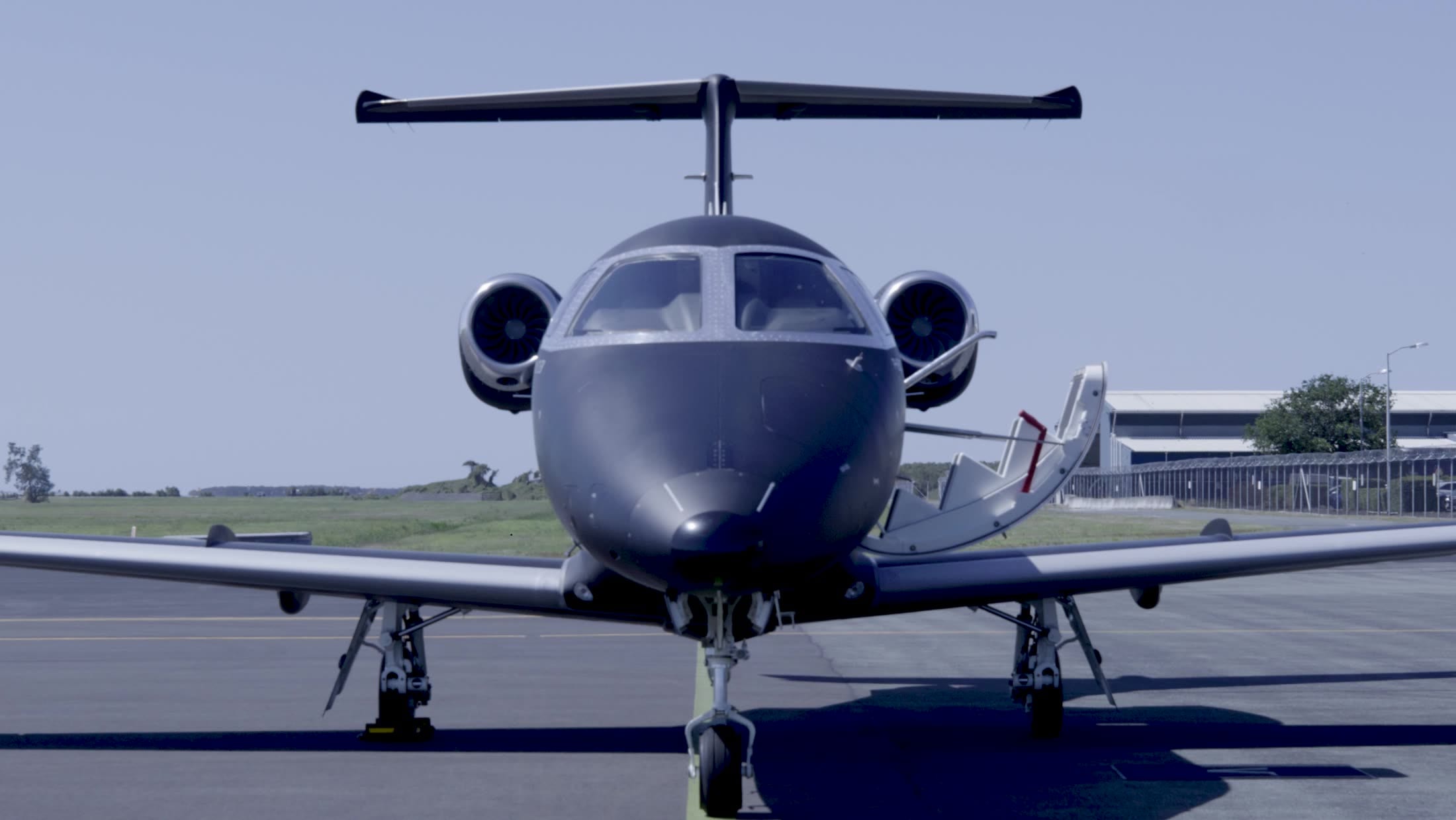 An Embraer Phenom head-on, poised on the apron