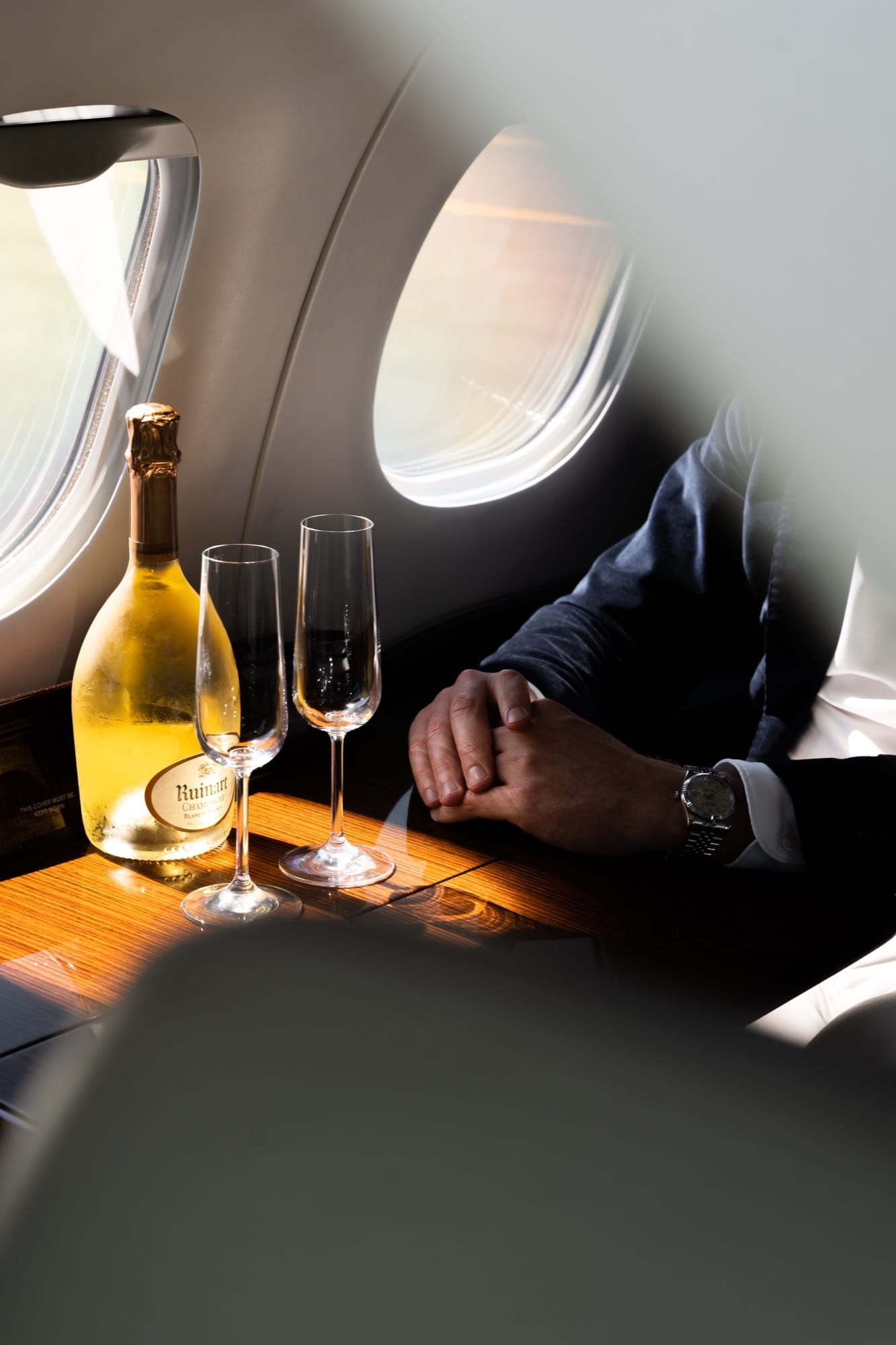 Champagne and two flutes on a polished cabin table beside the windows