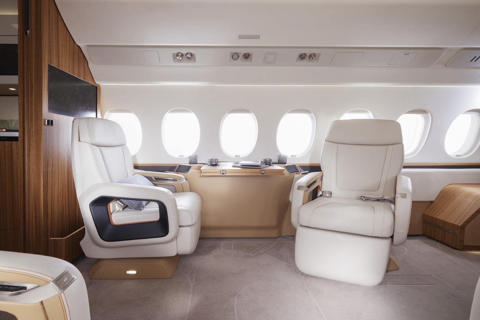The Falcon 6X cabin — the widest cross-section in business aviation, lit by thirty windows