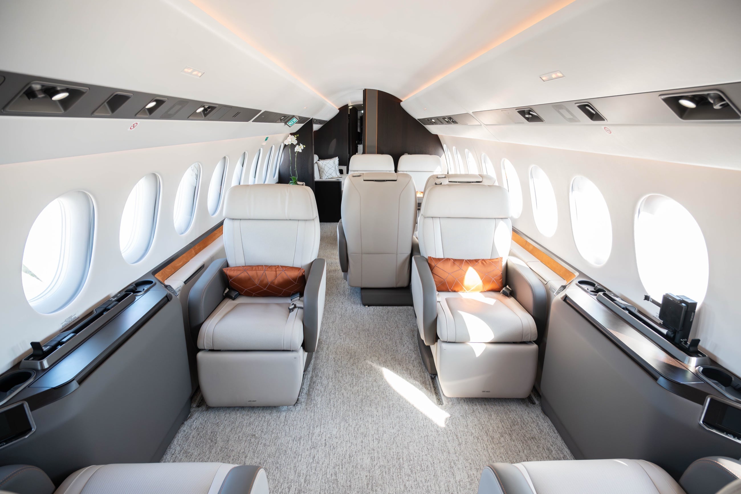 The sunlit cabin of a Dassault Falcon 8X, appointed in pale leather