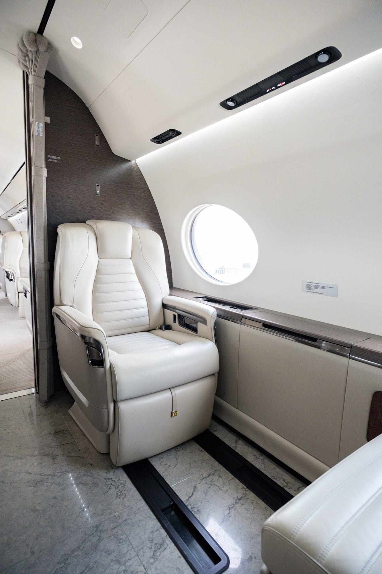 A single seat in the Gulfstream G700 cabin beside a panoramic oval window